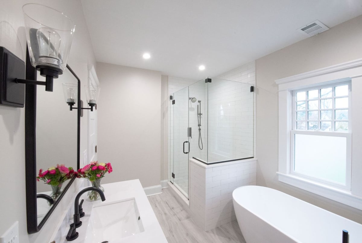 Bright and airy custom bathroom featuring large walk-in shower and white soaking tub in Caldwell, NJ by G&L and Sons Renovations