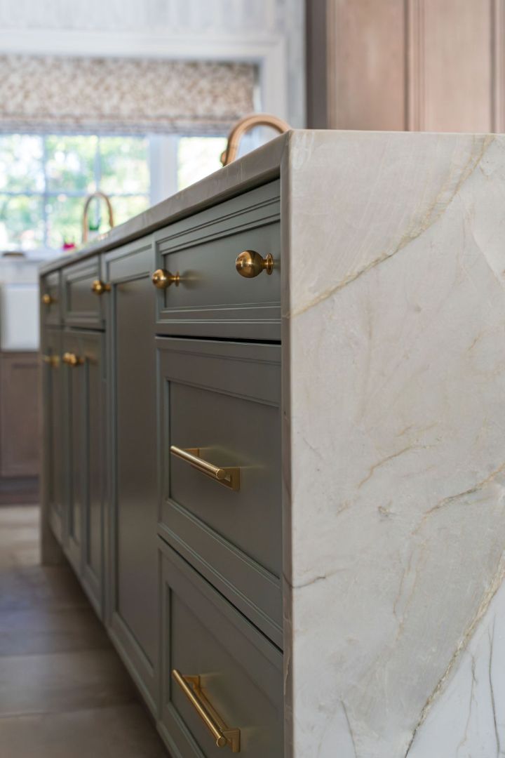 Close-up of marble waterfall countertop and brass hardware in a custom kitchen by G&L and Sons Renovations, Caldwell, NJ