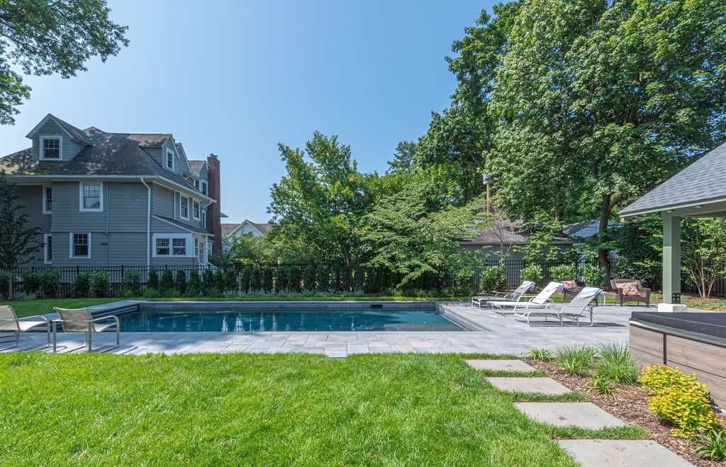 Modern poolscape with lounge chairs and pavers in Essex Fells, NJ by G&L and Sons Renovations