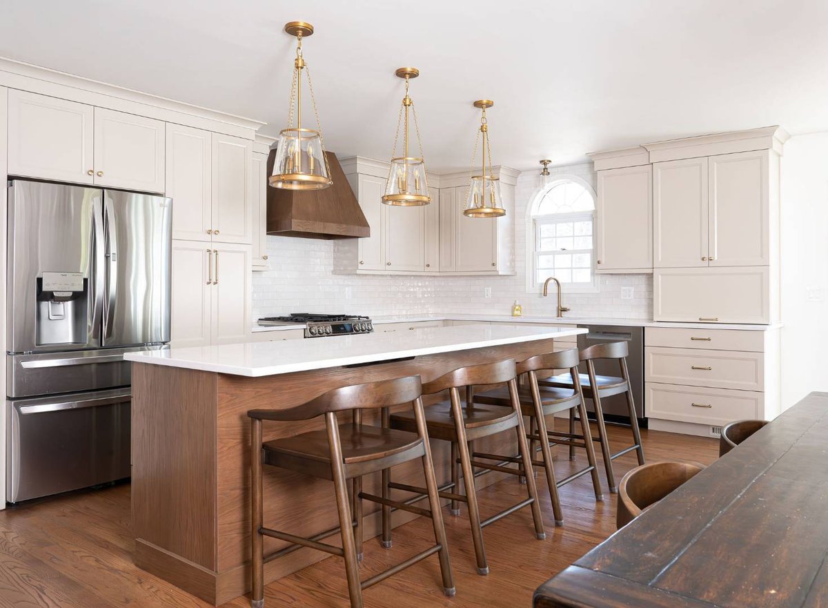 Elegant kitchen featuring wood island, brass lighting, and stainless appliances in a Caldwell, NJ home by G&L and Sons Renovations
