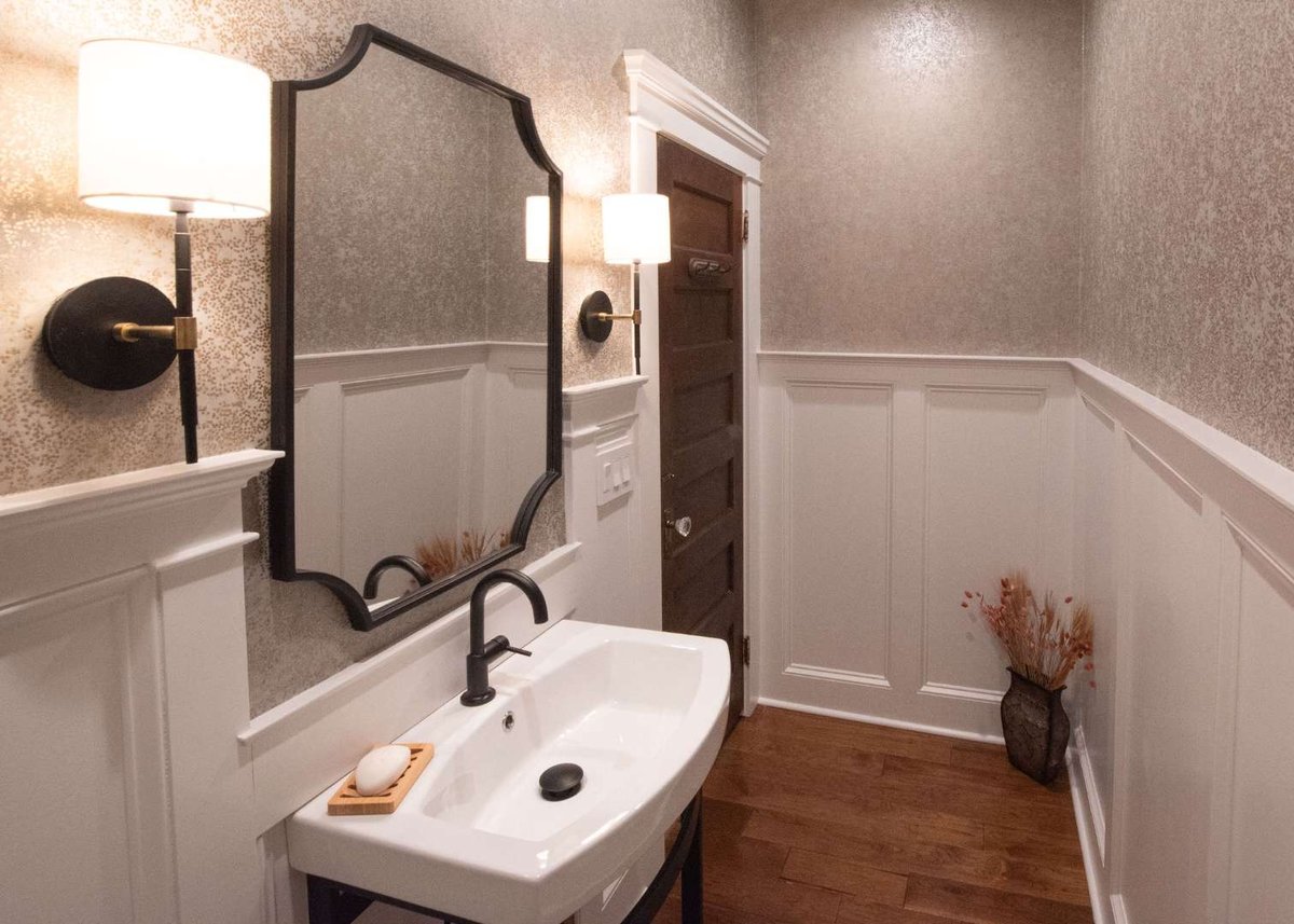 Elegant half bathroom with white paneling and bronze fixtures in a Caldwell, NJ custom home by G&L and Sons Renovations