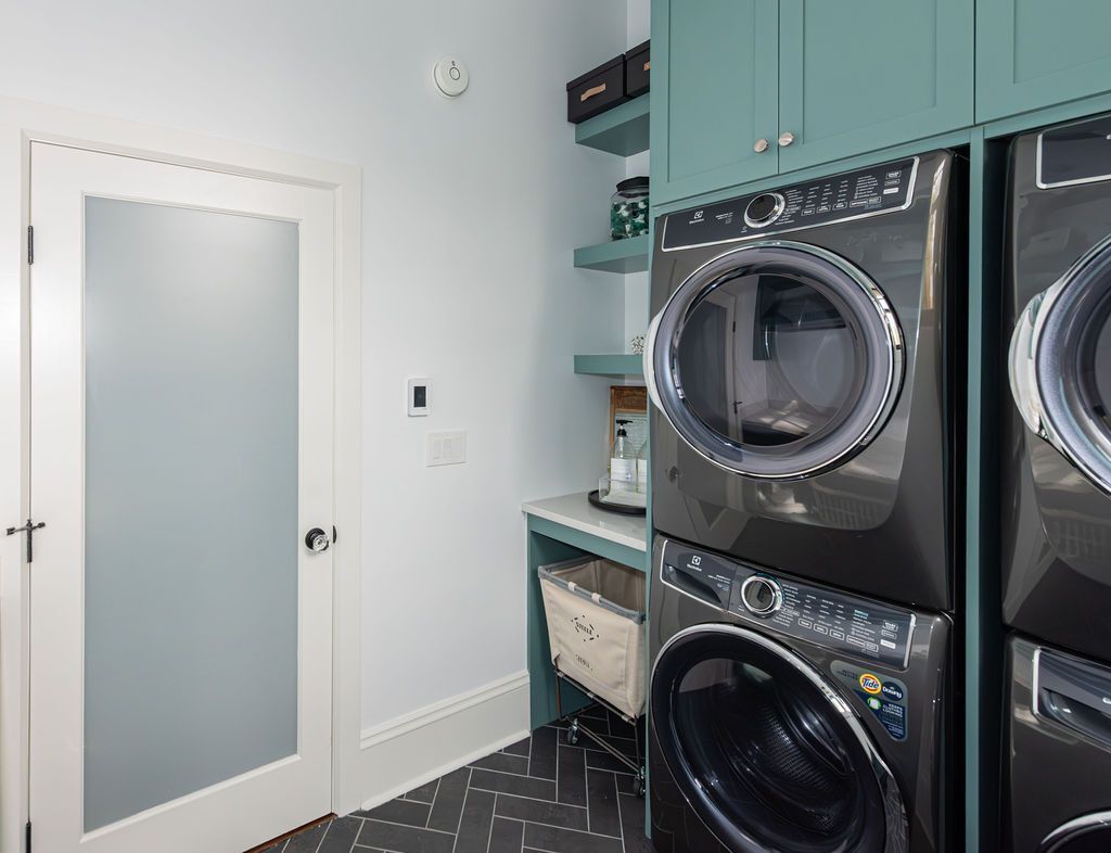 Custom laundry room with stacked washer-dryer and teal built-in cabinets by G&L and Sons Renovations, Caldwell, NJ