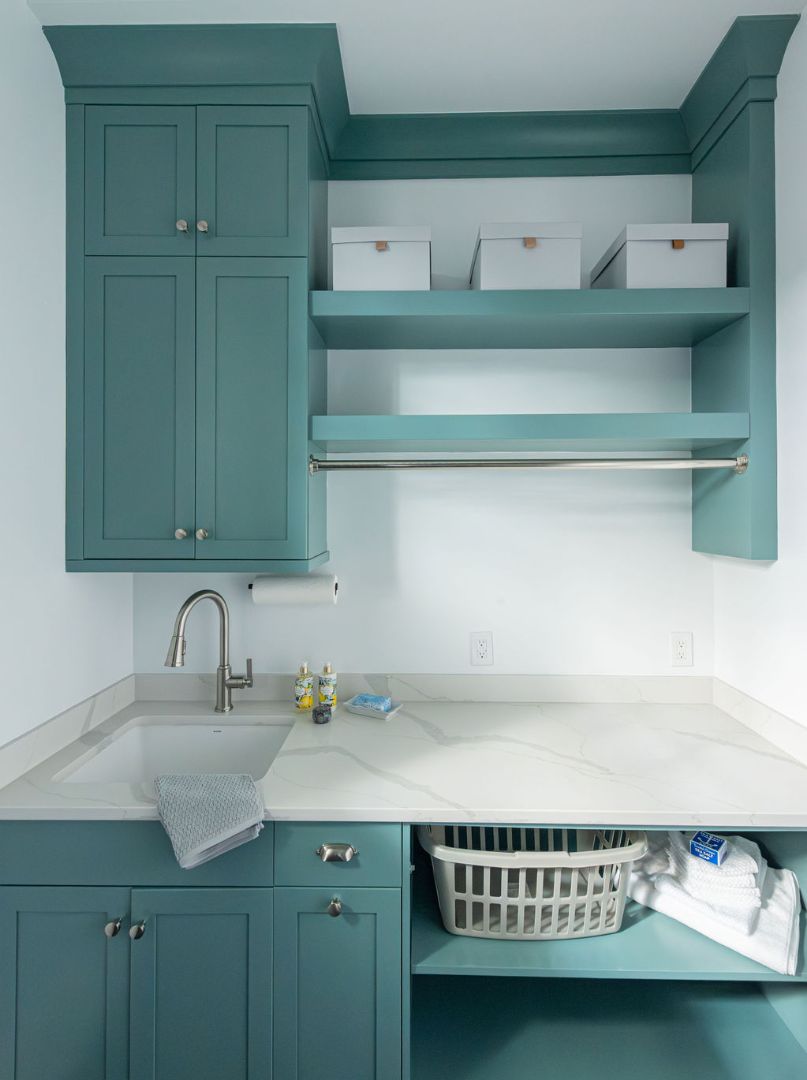 Organized laundry area featuring upper storage and marble countertops in a Caldwell, NJ home by G&L and Sons Renovations