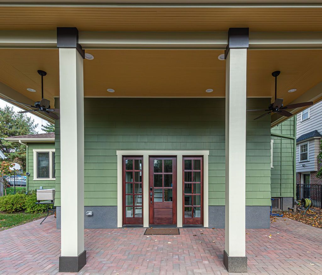 Short Hills, NJ covered outdoor entry with green siding and ceiling fans by G&L and Sons Renovations.