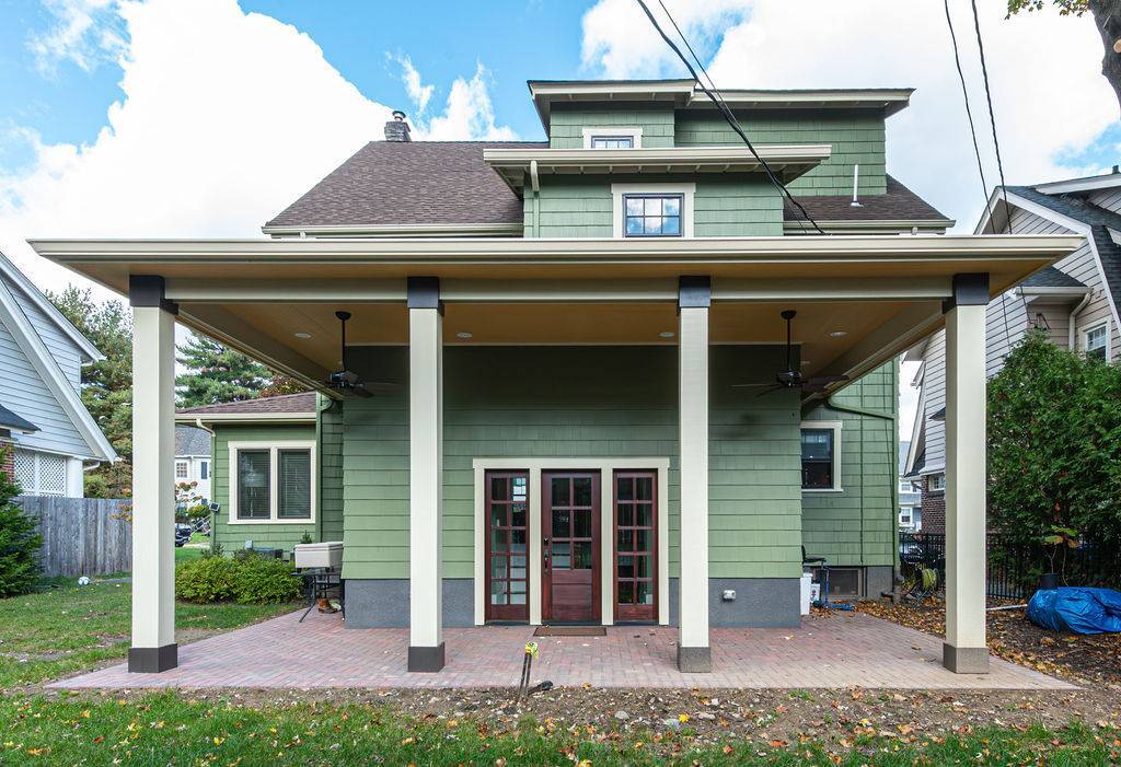 Exterior rear porch addition in Chatham Township, NJ by G&L and Sons Renovations with green siding and ceiling fans
