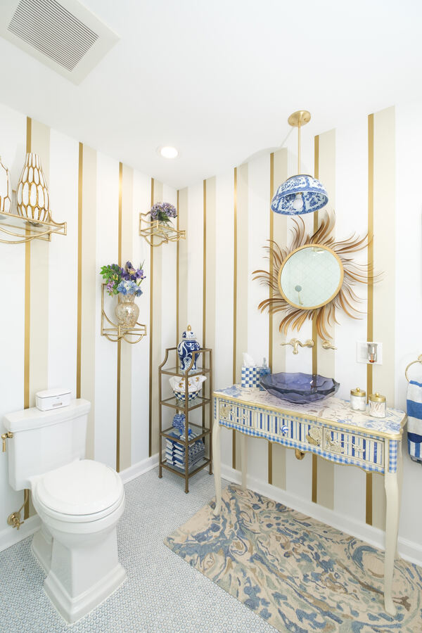remodeled bathroom in New Jersey with gold wallpaper and hardware