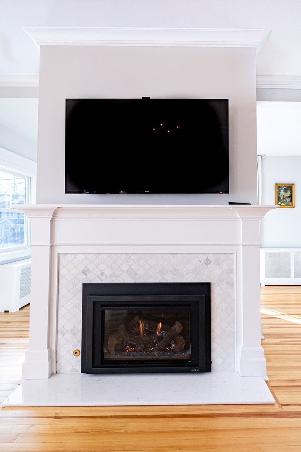 Electric fireplace with tile and a white mantel